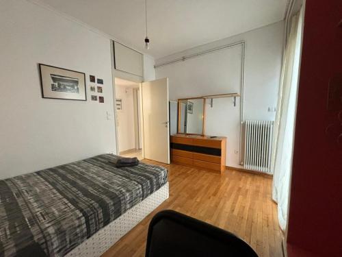 a bedroom with a bed and a dresser and a mirror at Cozy home in Kypseli in Athens