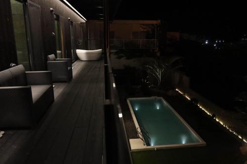 a bath tub sitting on top of a balcony at night at ＩＲＡＧＯ　ＡＲＴ　 ＨＯＴＥＬ 　THECAPE in Irago