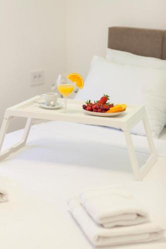 a white table with a plate of fruit and a glass of orange juice at Golden hill Vinča in Vinča