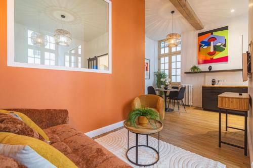 un salon avec un mur orange dans l'établissement MM Suites Loft Cathédrale, à Reims