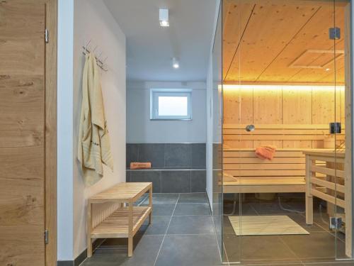 a bathroom with a shower with a bench and a table at Bergbiberhaus L in Piesendorf