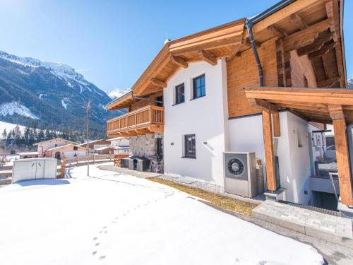 a house in the mountains with snow on the ground at Lodge Elise in Vorderkrimml