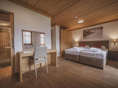 sypialnia z 2 łóżkami i biurkiem z krzesłem w obiekcie Bella Vista S w mieście Wald im Pinzgau