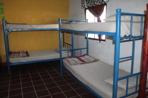 a room with three bunk beds in a room at Karim Hostel in Guatemala