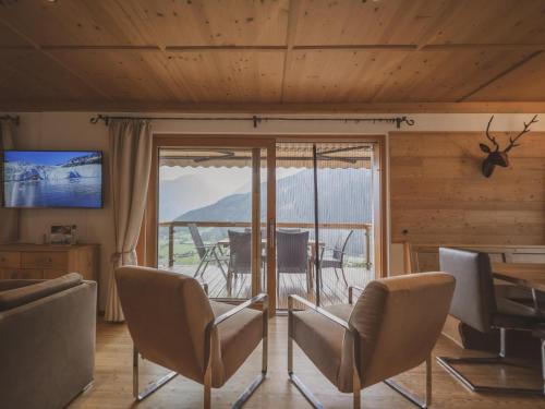 a living room with a table and chairs and a balcony at Bella Vista XL in Vorderwaldberg