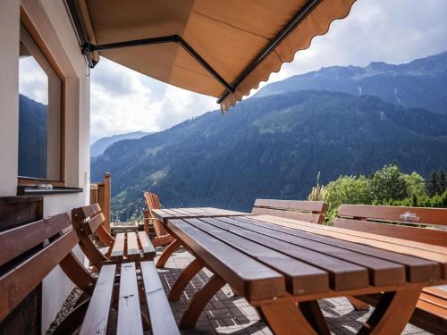 a wooden table and benches on a balcony with a view at Bella Vista S in Vorderwaldberg