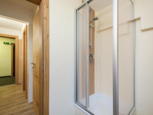 een glazen douchedeur in een kamer met een gang bij Rupertihof I in Saalbach Hinterglemm