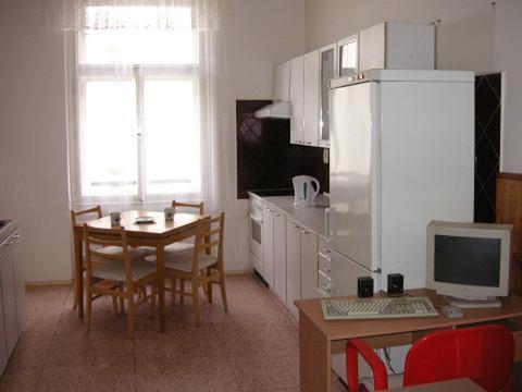 une cuisine avec une table et un bureau avec un ordinateur dans l'établissement Hostel Bell, à Prague