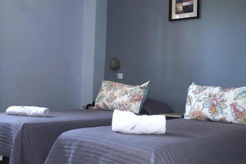 two beds sitting next to each other in a room at Hotel Sienna in Mendoza