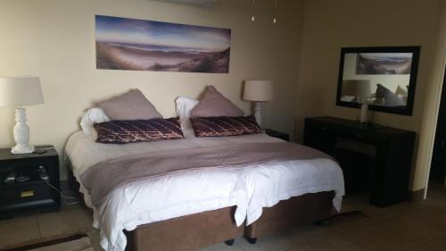 a bedroom with a bed with two pillows on it at Bonna Vista in Umdloti