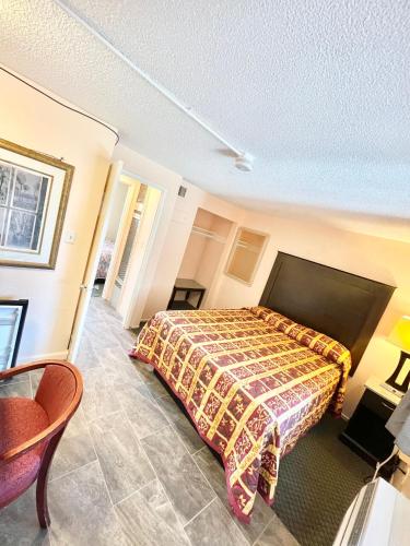 a bedroom with a bed with a blanket on it at Royal Lodge in Coalinga