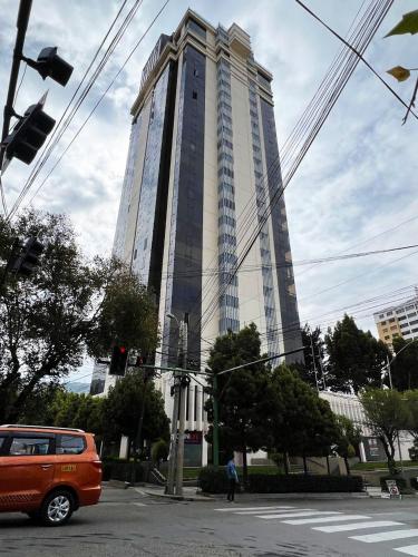 an orange van parked in front of a tall building at Apartamento en el mejor lugar frente a Embajada de Estados Unidos in La Paz