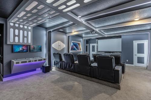 een filmzaal met zwarte stoelen en een scherm bij 41-Guest Capacity Mansion w TONS of Perks in Orlando
