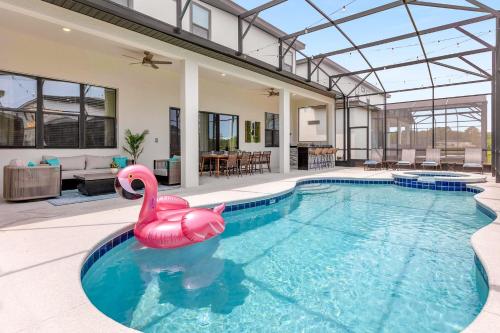奧蘭多的住宿－20PCT OFF - 41-Guest Capacity Mansion w TONS of Perks，一座房子里一座游泳池,里面有一个粉红色的天鹅