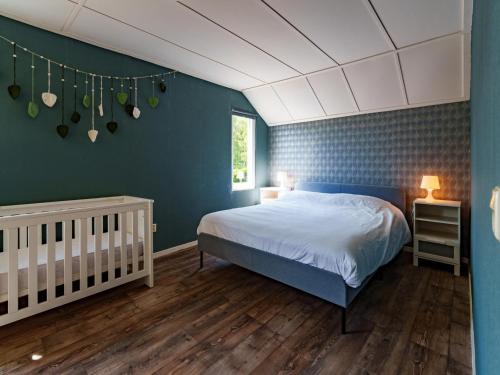 1 dormitorio con cama y pared azul en Achter de Vijf Linden, en Knegsel