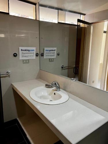 uma casa de banho com um lavatório e um espelho em Carolina's Hostel em Piura