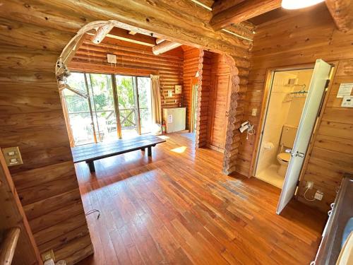 Habitación con banco en una cabaña de madera en Tokashiki Guest House, en Tokashiki