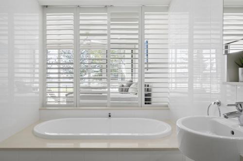 baño con bañera, lavabo y ventana en Allisee Apartments en Gold Coast