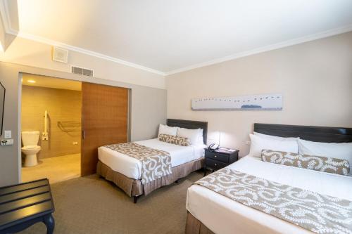 a hotel room with two beds and a bathroom at Crowne Plaza Managua by IHG in Managua