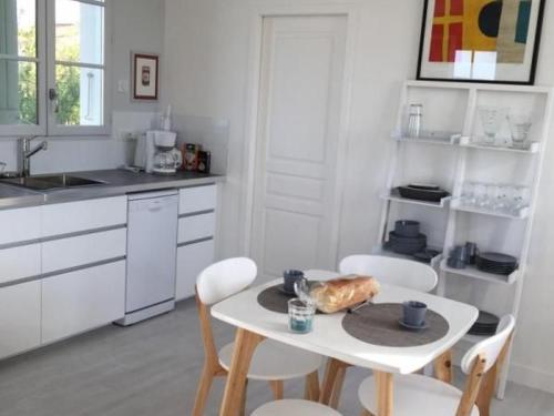 - une cuisine avec une table et un pain dans l'établissement Gîte en plein bourg avec terrasse ensoleillée, vélos à disposition et parking – proche thalasso et plages - FR-1-426-290, à Saint-Hilaire-de-Talmont