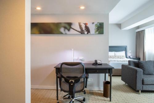 a hotel room with a desk and a bed at Crowne Plaza Managua by IHG in Managua