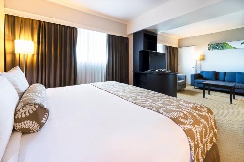 a hotel room with a bed and a couch at Crowne Plaza Managua by IHG in Managua