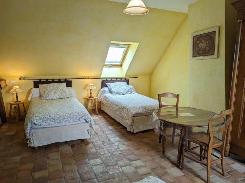 a bedroom with two beds and a table and a window at Gîte Lorcy, 3 pièces, 5 personnes - FR-1-590-40 in Lorcy