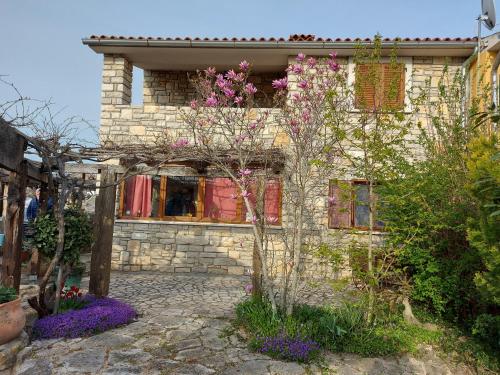 a stone house with flowers in front of it at Family friendly house with a swimming pool Krmed, Central Istria - Sredisnja Istra - 23175 in Bale