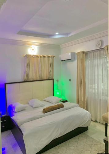 um quarto com uma grande cama branca num quarto em Hogis Exclusive Lodge, E1 ESTATE LEMMA em Calabar