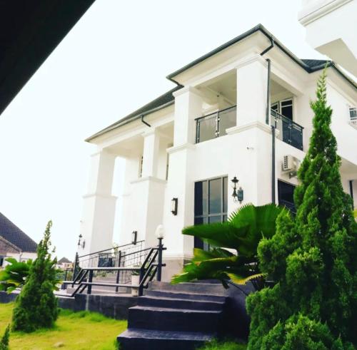 um edifício branco com escadas em frente em Hogis Exclusive Lodge, E1 ESTATE LEMMA em Calabar