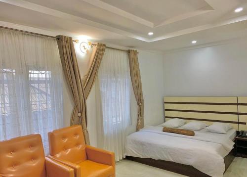 um quarto com uma cama e uma cadeira em Hogis Exclusive Lodge, E1 ESTATE LEMMA em Calabar