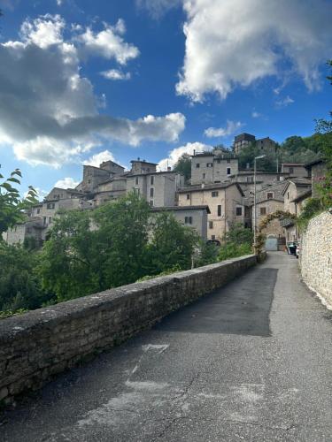 długi kamienny mur z budynkami w tle w obiekcie casa belvedere a Valle San Martino di Spoleto w mieście Spoleto