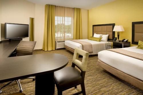 een hotelkamer met 2 bedden en een tafel bij Candlewood Suites Alexandria - Fort Bevoir, an IHG Hotel in Alexandria