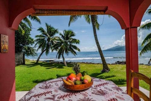 a bowl of fruit on a table with a view of the ocean at Bungalow Moana in Taravao