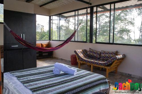 um quarto com uma rede de descanso, uma cama e um sofá em Bio-Hotel entre café, bosque y montañas em Cachipay
