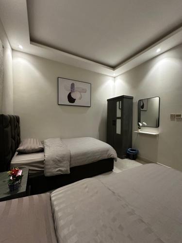 um quarto de hotel com duas camas e um espelho em هابي رومز em Al Khobar