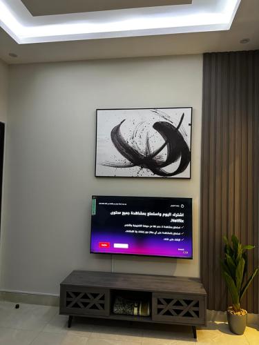 TV de pantalla plana en la pared de la sala de estar. en هابي رومز en Al Khobar