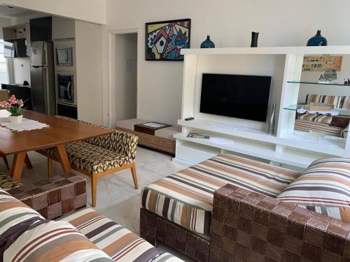 a living room with two couches and a television at Beautiful condo by the shore in Santos