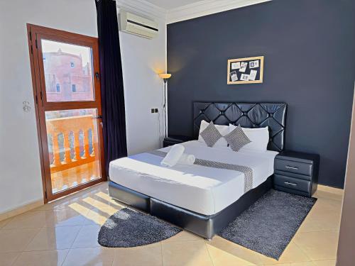 Un dormitorio con una gran cama blanca y una ventana en Residence Chay - Appartement de luxe en Ouarzazate