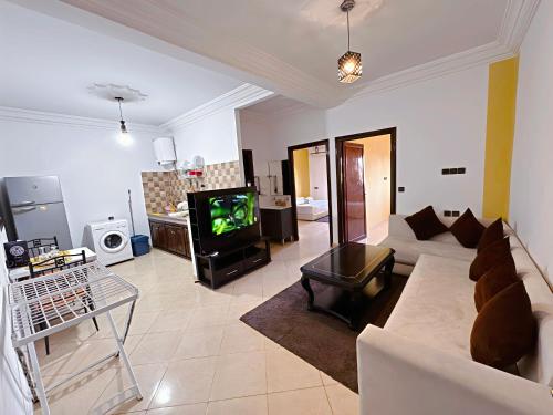 uma sala de estar com um sofá branco e uma televisão em Residence Chay - Luxury Appart em Uarzazate