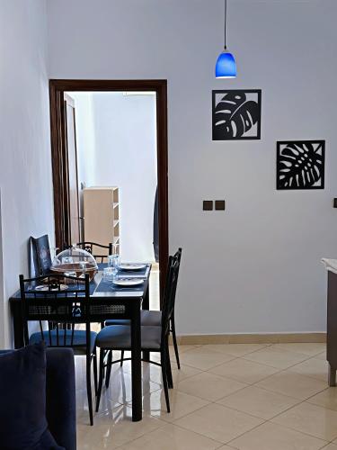 a dining room with a black table and chairs at Residence Chay - Luxury Appart in Ouarzazate