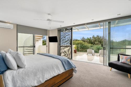 a bedroom with a bed and a sliding glass door at Amazing Water Views with Direct Beach Access in Marcoola