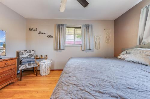 een slaapkamer met een bed, een stoel en een raam bij Charming 2-Bedroom Home With Private Office and Backyard in Rancho Cordova