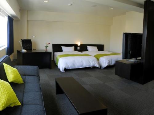 久留米的住宿－久留米思捷環球酒店，酒店客房,设有两张床和一张沙发