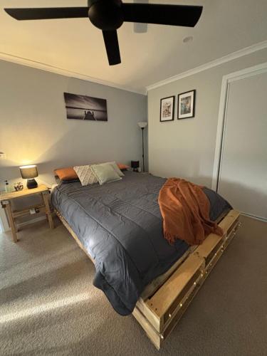 a bed in a bedroom with a ceiling fan at Kima Quarters in Swan Hill