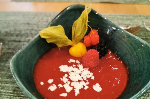 a green bowl of red sauce with berries and cheese at Holiday Inn - Osnabrück by IHG in Osnabrück