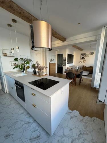une cuisine avec un comptoir blanc et une salle à manger dans l'établissement Appartement Cosy, à Biot