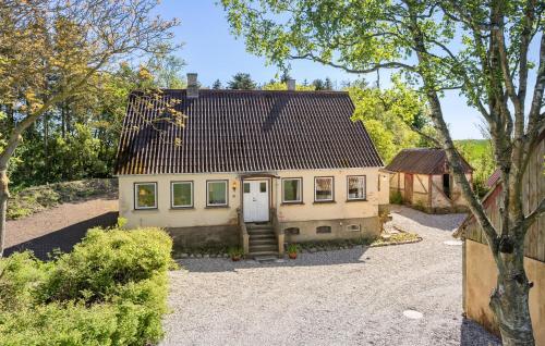 a small house with a white door in a driveway at Nice Home In Tranekær With Kitchen in Tranekær