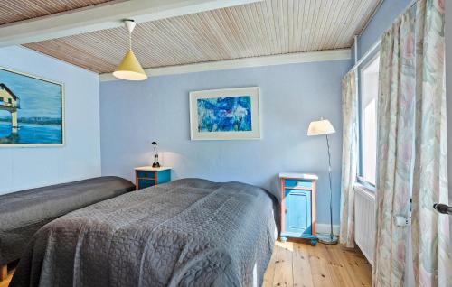 1 dormitorio con paredes azules, 1 cama y ventana en Nice Home In Tranekr With Kitchen, en Tranekær
