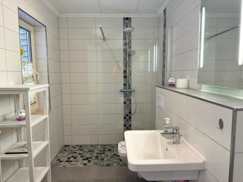a white bathroom with a sink and a shower at ETW Hausberg 45 - Fr Schwenn in Sassnitz